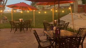 Outdoor dining patio at Bryce Canyon National Park restaurant with metal tables, chairs, and warm string lights.