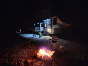 Chosa Campground at Carlsbad Caverns National Park lit by a campfire with an RV and campers at night.
