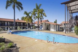 Outdoor hotel pool area with palm trees and stucco buildings at Channel Islands National Park.