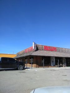 Gift shop building along the park entrance at Carlsbad Caverns National Park, with rustic wood siding and red lettering visible.