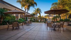 Outdoor hotel courtyard with tables and umbrellas in Channel Islands National Park lodging facility.