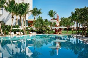 Hotel pool area with palm trees and clear blue water near Biscayne National Park.