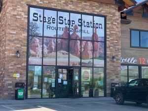 Exterior of a roadside eatery at Bryce Canyon National Park with a brick façade and a large mural on the windows.