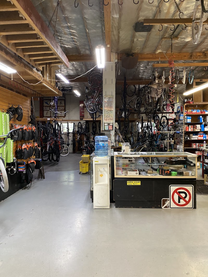 Inside a bike shop gift area at Arches National Park, with hanging bikes, parts shelves, and a glass display counter.