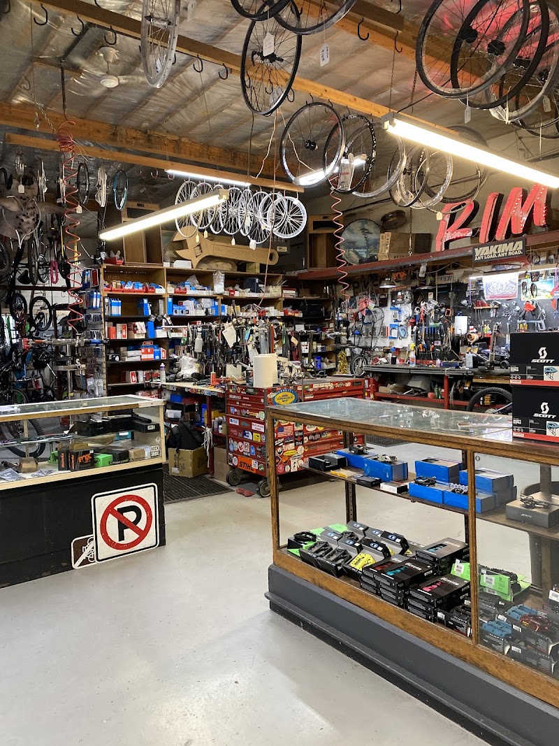 Inside a busy cycling shop with bikes hanging from the ceiling, shelves of parts, and display cases at Arches National Park.