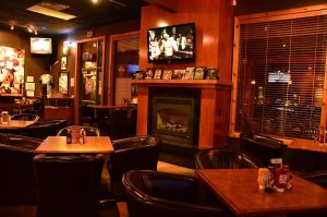 Dining area inside a Zion National Park restaurant, with leather chairs, wood furnishings, and a warm fireplace.