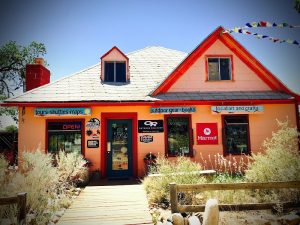 Capitol Reef National Park gift shop exterior with peach walls, red trim, and a sunny blue sky.