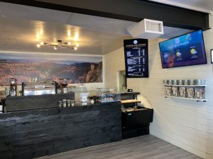 Interior of a coffee shop at Bryce Canyon National Park with a stone counter and menu boards.