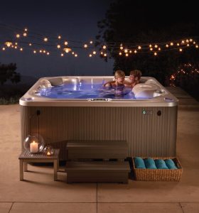 Night scene of a hot tub with string lights and two people relaxing in Black Canyon of the Gunnison National Park.