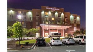Nighttime exterior view of a modern hotel entrance in downtown Columbia near Congaree National Park.
