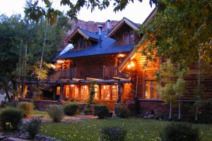 Capitol Reef National Park rustic lodge with log architecture glows warmly at dusk, inviting visitors.