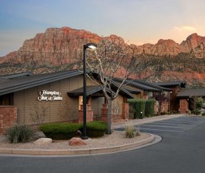 Hotel entrance in Springdale with Zion National Park’s dramatic red rock cliffs in the background.