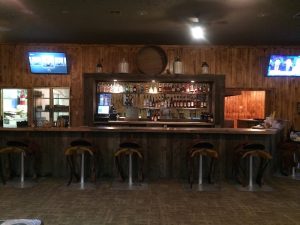Interior of a rustic bar at Bryce Canyon National Park, with a wood-paneled counter and stools.
