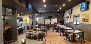 Interior view of Lucky Bull Grill at Carlsbad Caverns National Park, showcasing dining tables, TVs, and a casual eatery setting.