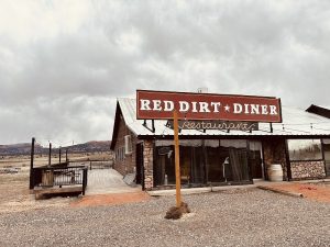 Diner storefront with rustic stone and wood facade in Bryce Canyon National Park, with a dramatic desert backdrop.