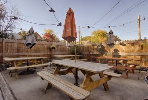 Outdoor cafe patio with wooden picnic tables and string lights near Congaree National Park in West Columbia.