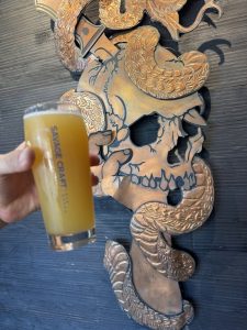 Decorative skull and snake wall art on a dark wooden wall at a craft brewery near Congaree National Park.