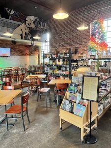 Interior of a brick-walled cafe at Congaree National Park with wooden tables and shelves.