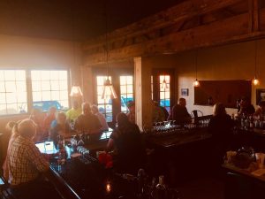 Bar interior at Capitol Reef National Park with warm pendant lights and patrons at the counter.