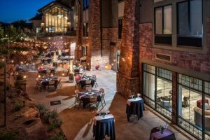 Courtyard dining area at a hotel near Zion National Park in Springdale, lit by string lights at twilight.