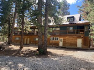 Pinewoods Resort lodge at Bryce Canyon National Park, a two-story wooden building nestled among tall pines with a wraparound balcony.