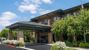 Hotel-style lodging entrance with green canopies and flowering shrubs near Channel Islands National Park.