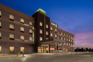 Lodging hotel exterior near Carlsbad Caverns National Park at twilight, with illuminated entrance.