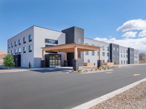 Exterior of a contemporary hotel in Moab near Canyonlands National Park, featuring a wood-and-stone entrance canopy.