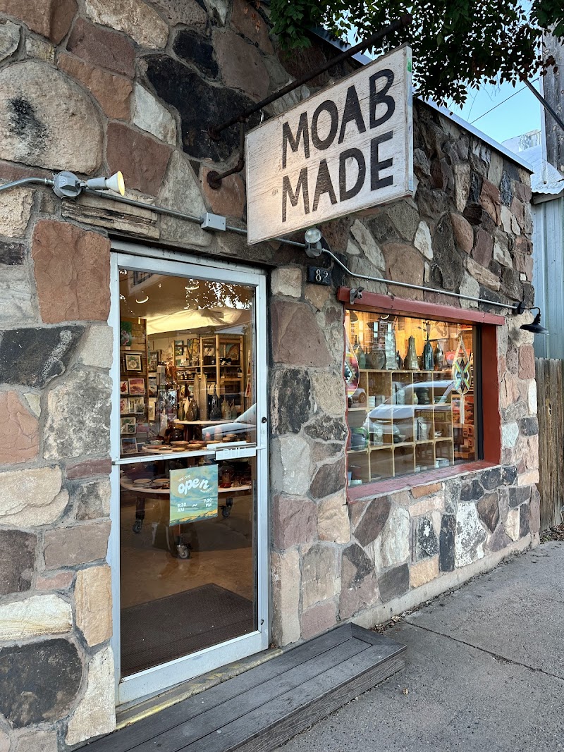 Gift shop with a stone facade and a large window displaying colorful pottery and crafts near Arches National Park.