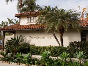 Exterior of a lodging building in Channel Islands National Park with a red-tiled roof and palm trees.