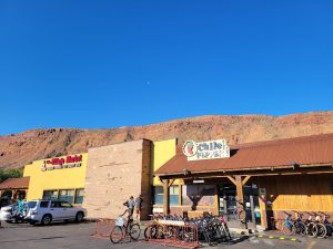 Bike shop storefront at Canyonlands National Park, with bicycles parked outside against a desert hillside backdrop.