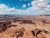 Vast red rock canyon and layered mesas overlook a winding river at Dead Horse Point in Arches National Park, Utah.