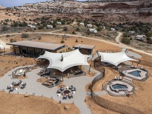 Moab lodging complex with white shade sails at Canyonlands National Park, built amid desert cliffs and red rock surroundings.