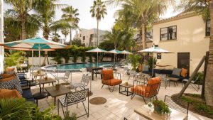 Poolside lounge area with umbrellas and palm trees at a Biscayne National Park lodging near Miami.