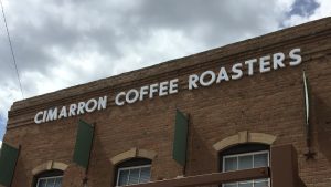 Brick building storefront with a large coffee shop sign along a park road in Black Canyon of the Gunnison National Park.