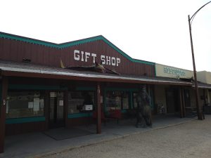 Gift shop in White's City near Carlsbad Caverns National Park storefront with a statue out front and rustic exterior.