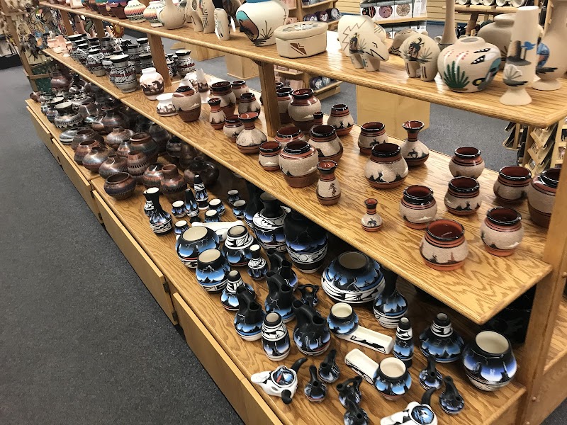 Wooden shelves overflow with blue-and-white and earthy pottery, bowls and vases of various sizes in Arches National Park gift shop.