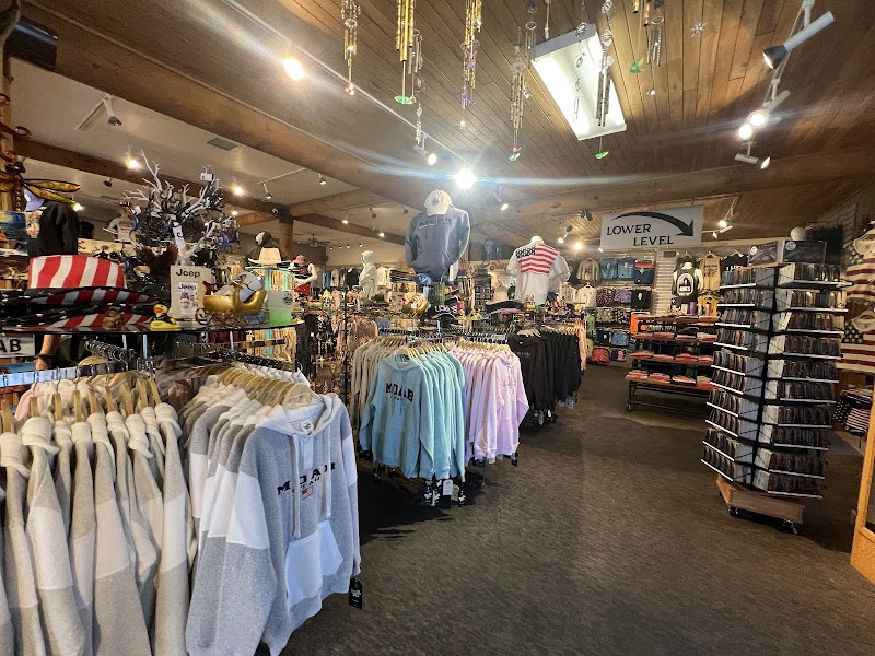 Inside Arches National Park gift shop, rows of hoodies and tees, shelves of souvenirs, and ceiling ornaments.