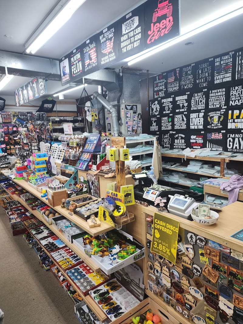 Inside an Arches National Park gift shop with long wooden counters, shelves of souvenirs, magnets and postcards.