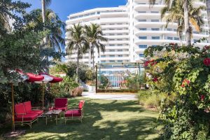 Lawn at a Miami Beach hotel with red seating and palm trees, near Biscayne National Park.