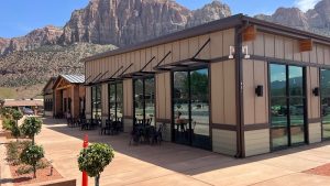 Gift shop and bakery exterior along Zion Canyon in Zion National Park, with sandstone cliffs rising in the background.