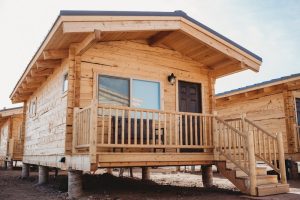 Wooden lodge-style cabin on stilts with a front porch in Capitol Reef National Park, Muddy Creek area.
