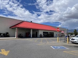 Storefront with a bright red metal roof and wide glass doors sits in a paved parking lot at Black Canyon of the Gunnison National Park.