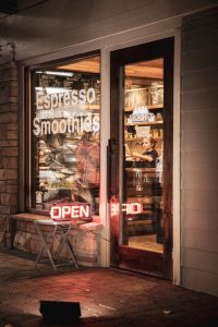 Exterior view of a small cafe storefront in Zion National Park, with espresso and smoothies signage in the window.