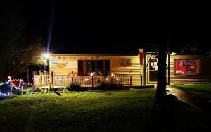 Exterior of a lit lodging building in Black Canyon of the Gunnison National Park at night, with string lights along a deck.
