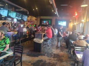 Indoor bar area at Black Canyon Of The Gunnison National Park, with multiple televisions and patrons.