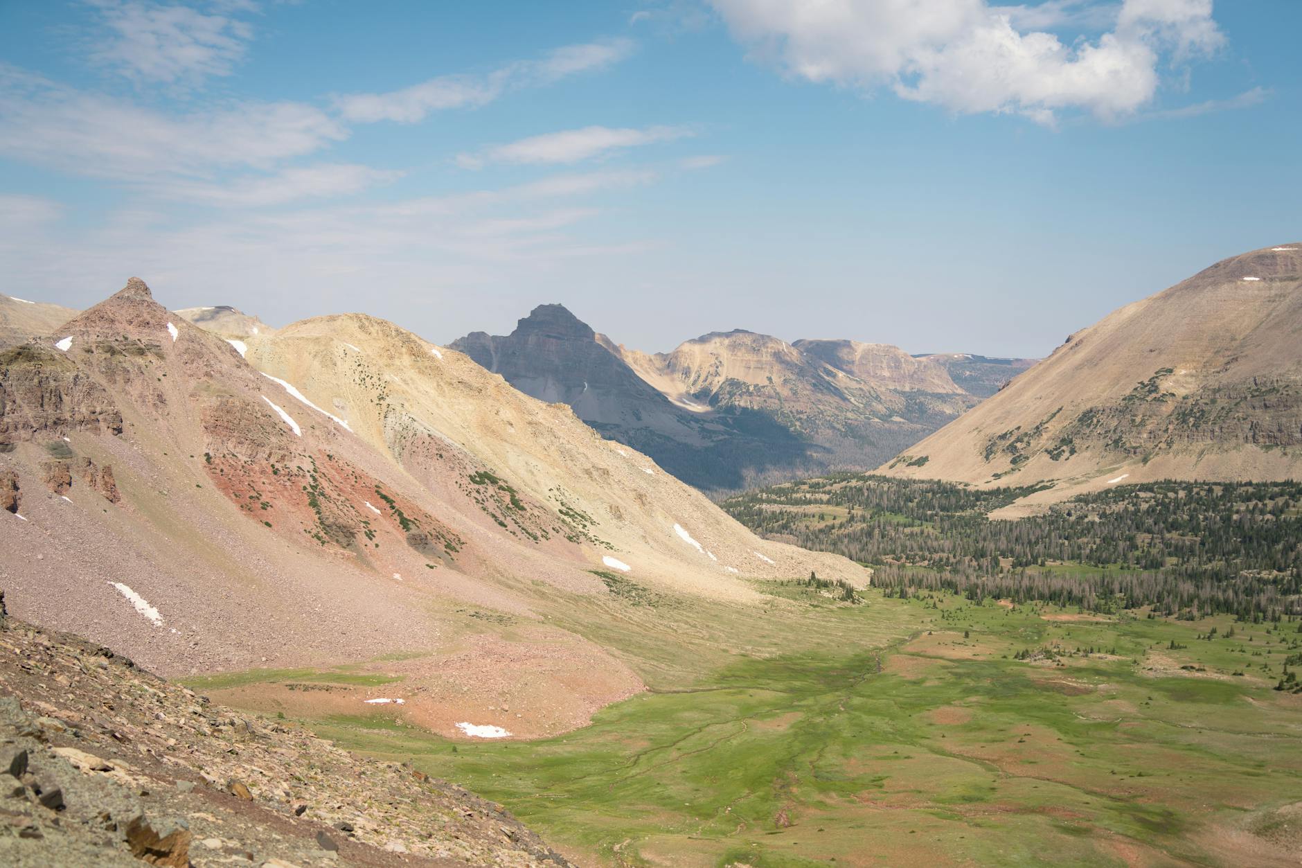 Explore the breathtaking landscape of Utah's Uinta Mountains with vibrant green valleys and towering peaks.