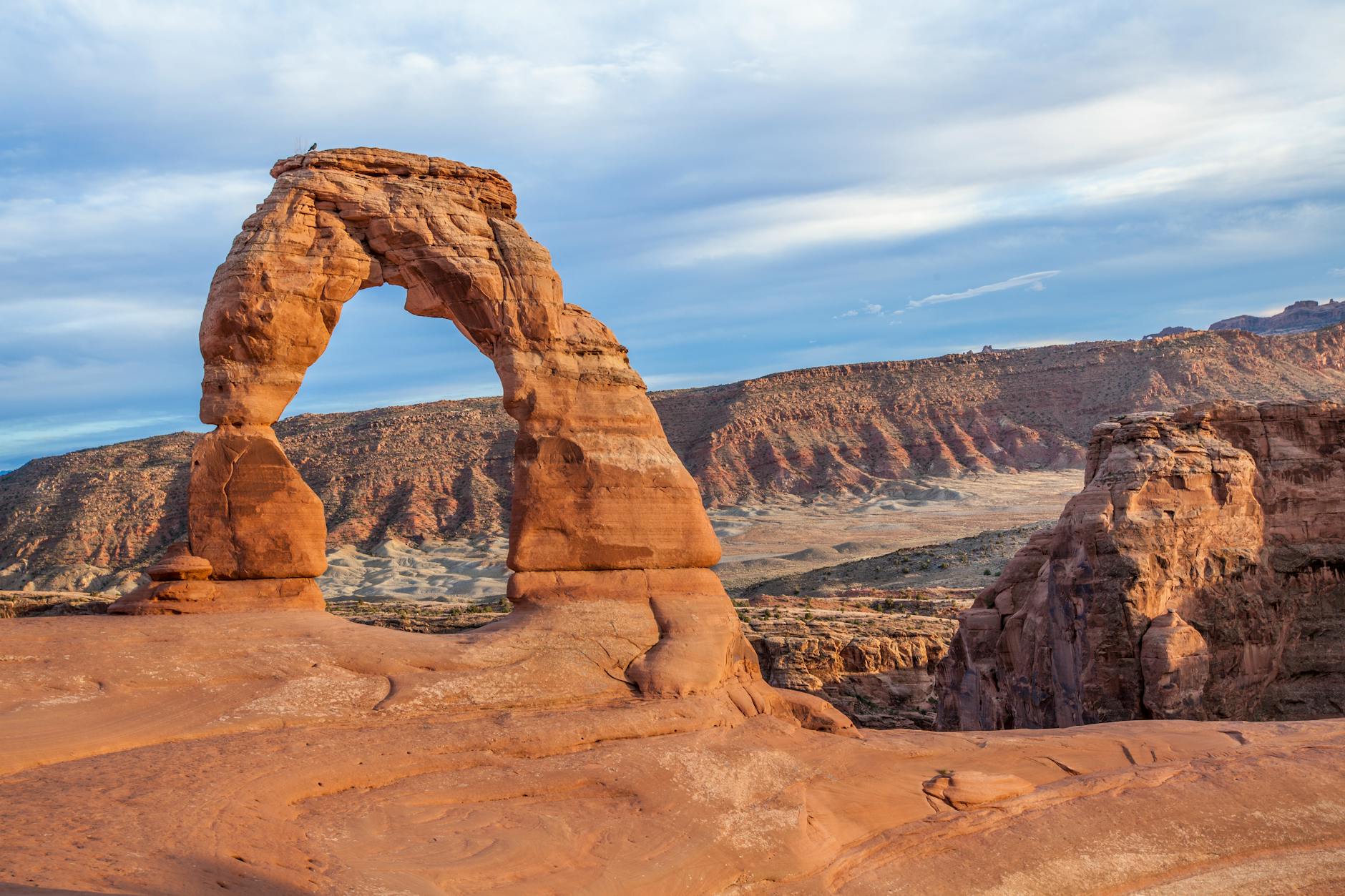 Spectacular view of the Delicate Arch in Arches National Park, Utah, against a vast desert landscape.