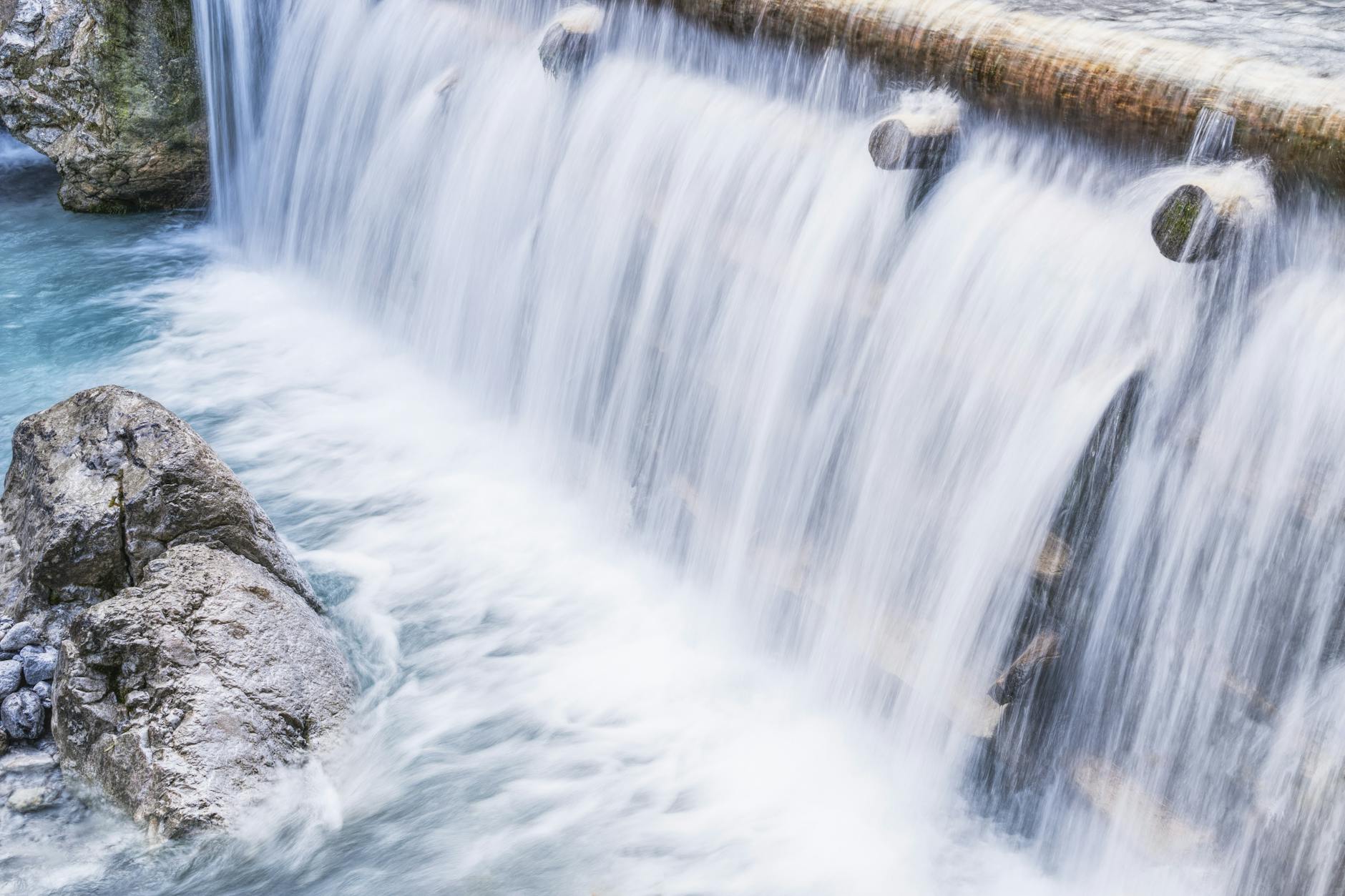 Tranquil waterfall flowing over rocks, creating a serene and picturesque scene in nature.