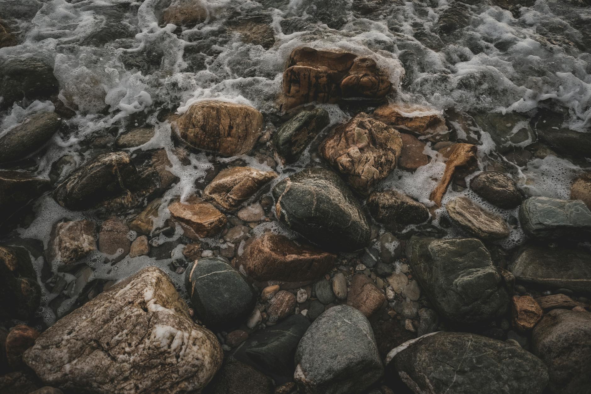 A dramatic close-up of ocean waves splashing against coastal rocks, capturing natural textures.